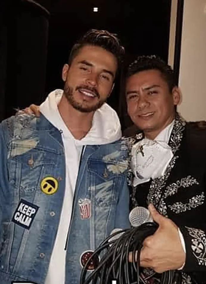 Integrante de Legado Real con un invitado especial y un micrófono
